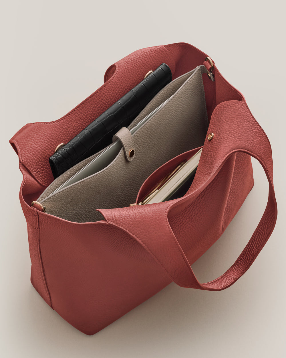 Open tote bag with multiple items inside including two pouches.