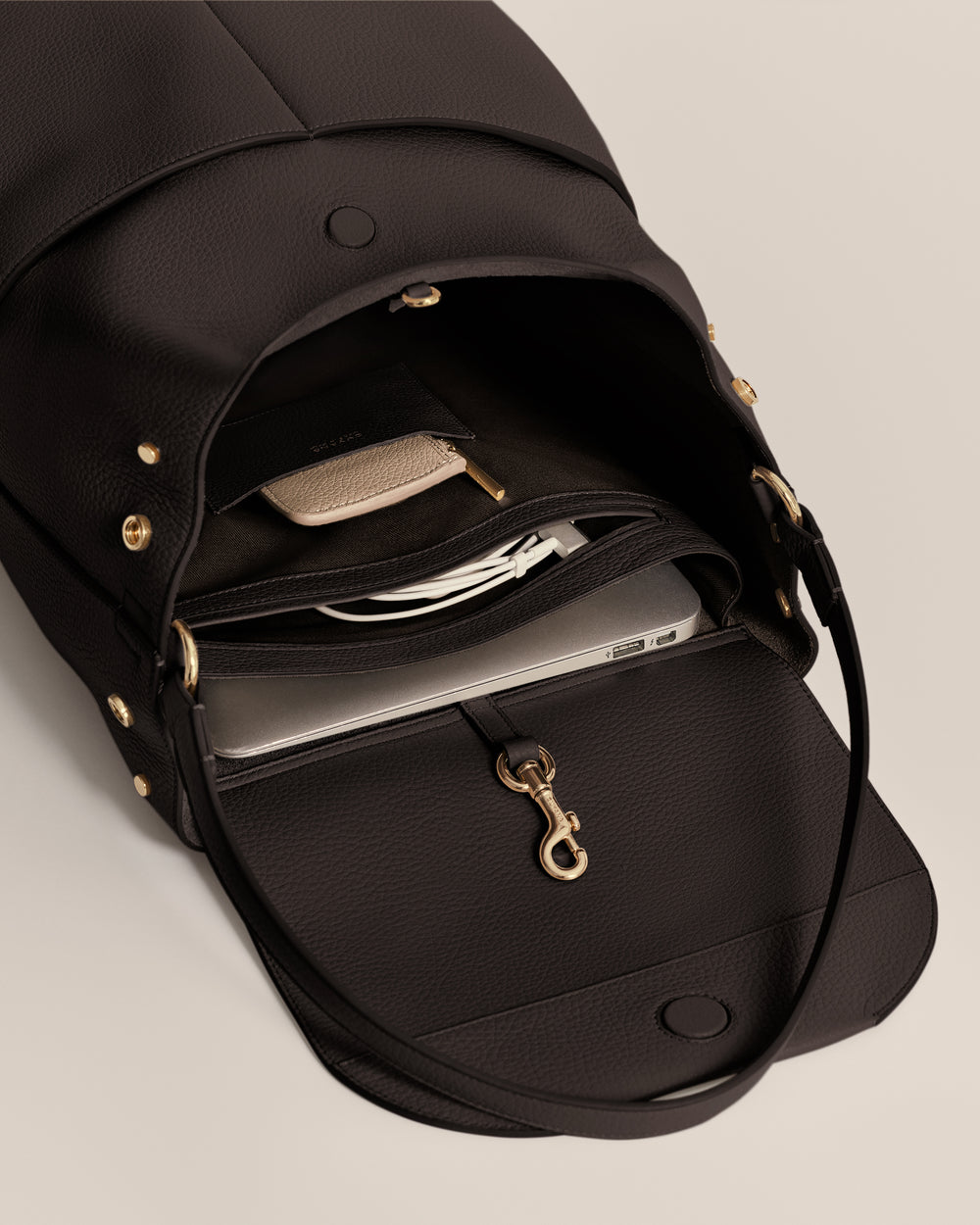 Open travel bag with a laptop and small accessories inside.