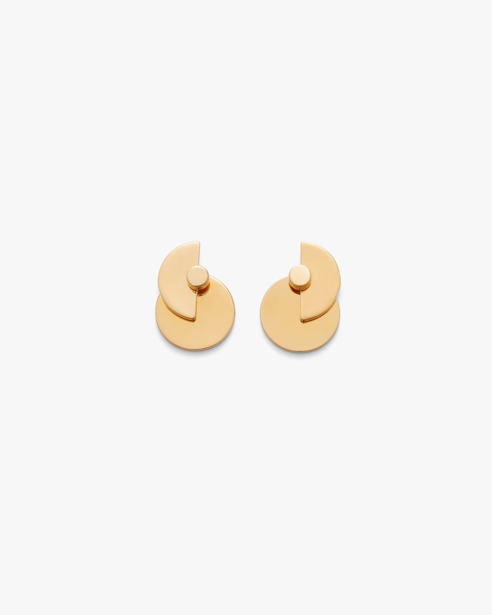Geometric layered circular earrings on a plain background.