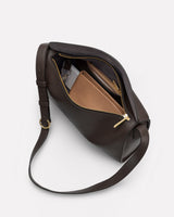 Open crossbody bag with items inside, showing a wallet and small pouch.