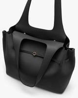 Large textured tote bag with a circular clasp on the front.