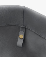 Close-up of a leather interior with a metal button detail.