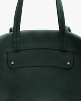 Close-up of the top part of a tote bag with handles and two rivets.