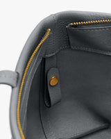 Open handbag interior with zipper pocket and snap closure.