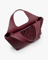 Handbag with a floral detail and round handle.