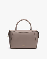 A handbag with a top handle and a zip closure on a plain background.
