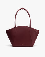 Handbag with curved top and two handles shown against plain background.