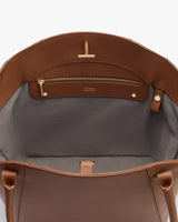 Open handbag showing inner pocket with zipper and a small buttoned strap.