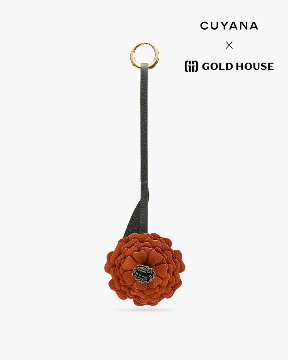 Floral keychain with a round loop and the words Cuyana and Gold House visible.
