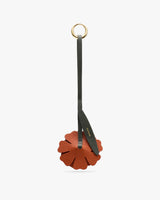 Floral-shaped leather keychain with long strap and metal ring.