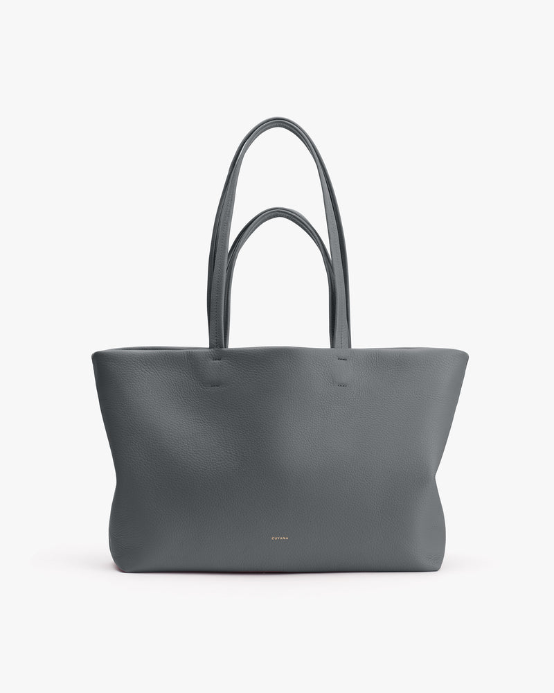 Large tote bag with long handles on plain background