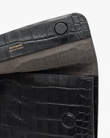Clutch with croc-embossed leather and brand label inside.