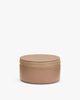 Round zippered jewelry case on white background.