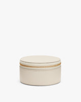 Round zippered case with textured surface.