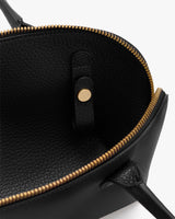 Open handbag with visible zipper and buttoned strap inside