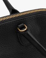 Close-up of a bag with a zipper and handle loop.