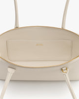 Open handbag with visible zipper and interior pocket.