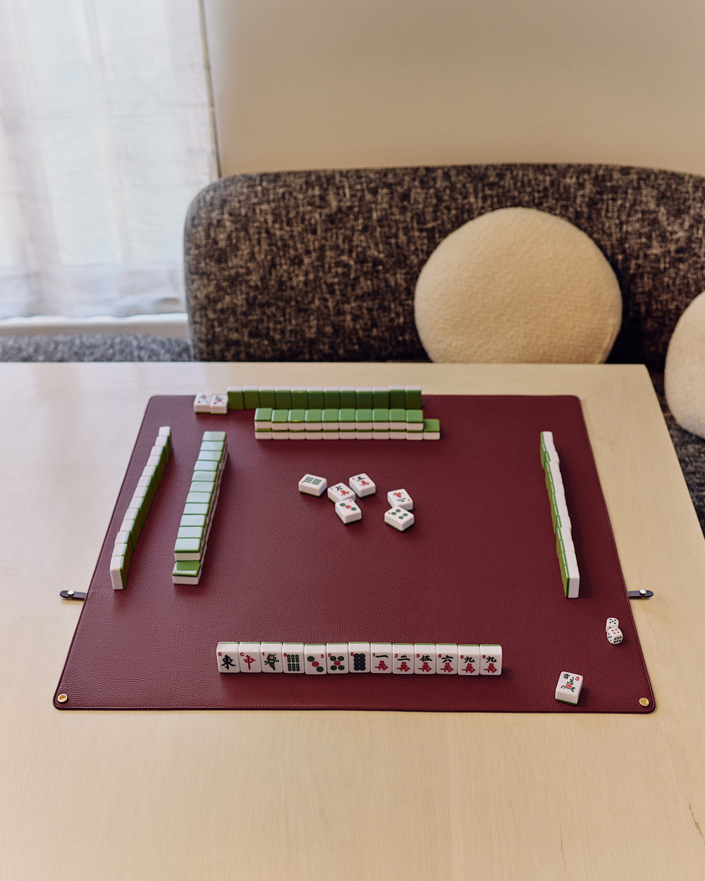 Mahjong tiles arranged on a table in a living room setting.