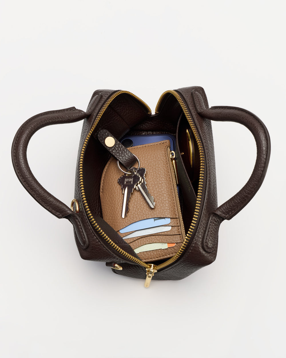 Open handbag with phone, wallet, keys, and cards inside.