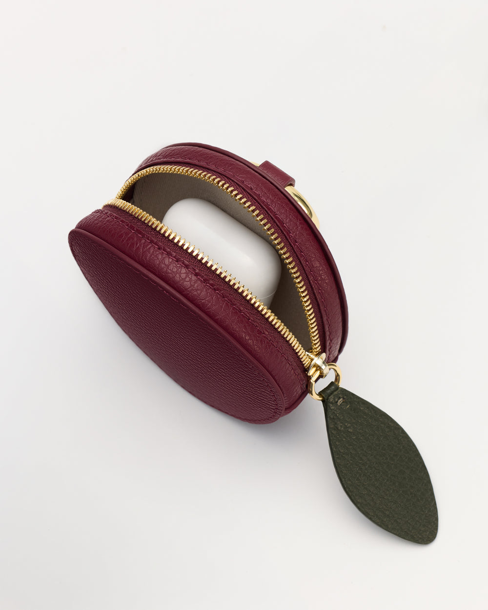 Round zippered leather coin purse with a leaf-shaped tag.