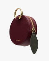 Round leather pouch with a zipper and metal ring attachment.