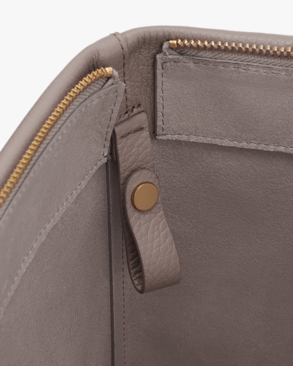 Close-up of the interior of a bag with zipper and button detail.