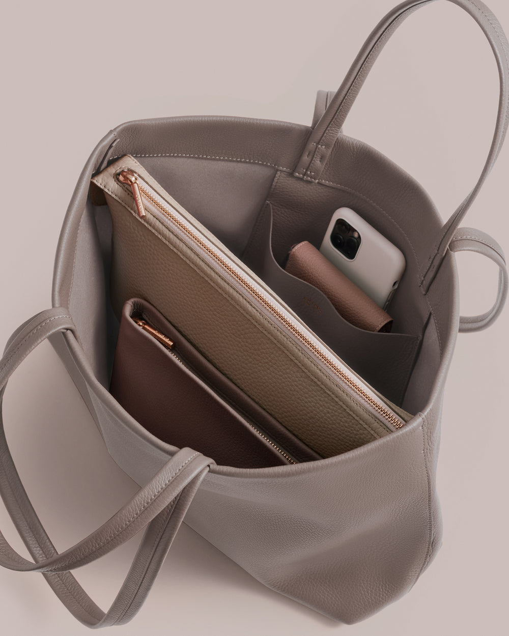 Open tote bag with pouches, wallet, and phone inside.