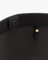 Close-up of a bag's interior with a button and gold stud detail.