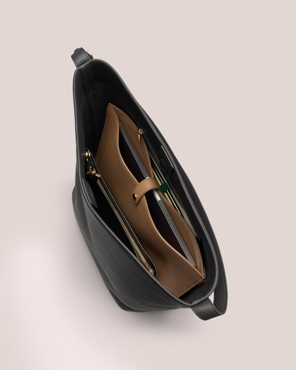 View inside an open tote bag with a brown pouch and zipper compartments.