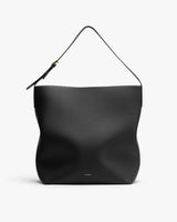 Handbag with single shoulder strap and subtle logo near base.