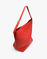 A shoulder bag with an adjustable strap and open top.