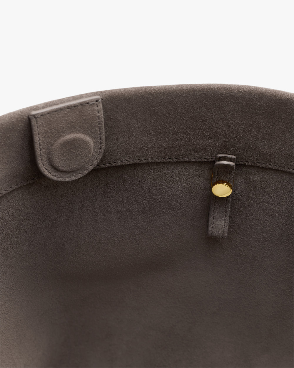 Open top of a bag with button closure inside.