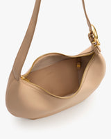 A hobo bag with a zipper partially open showing interior lining and a clasp on the strap.