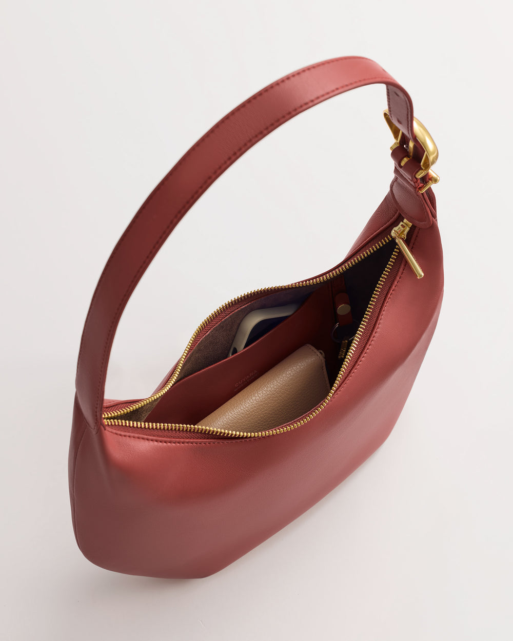 Open handbag with visible wallet and phone inside.