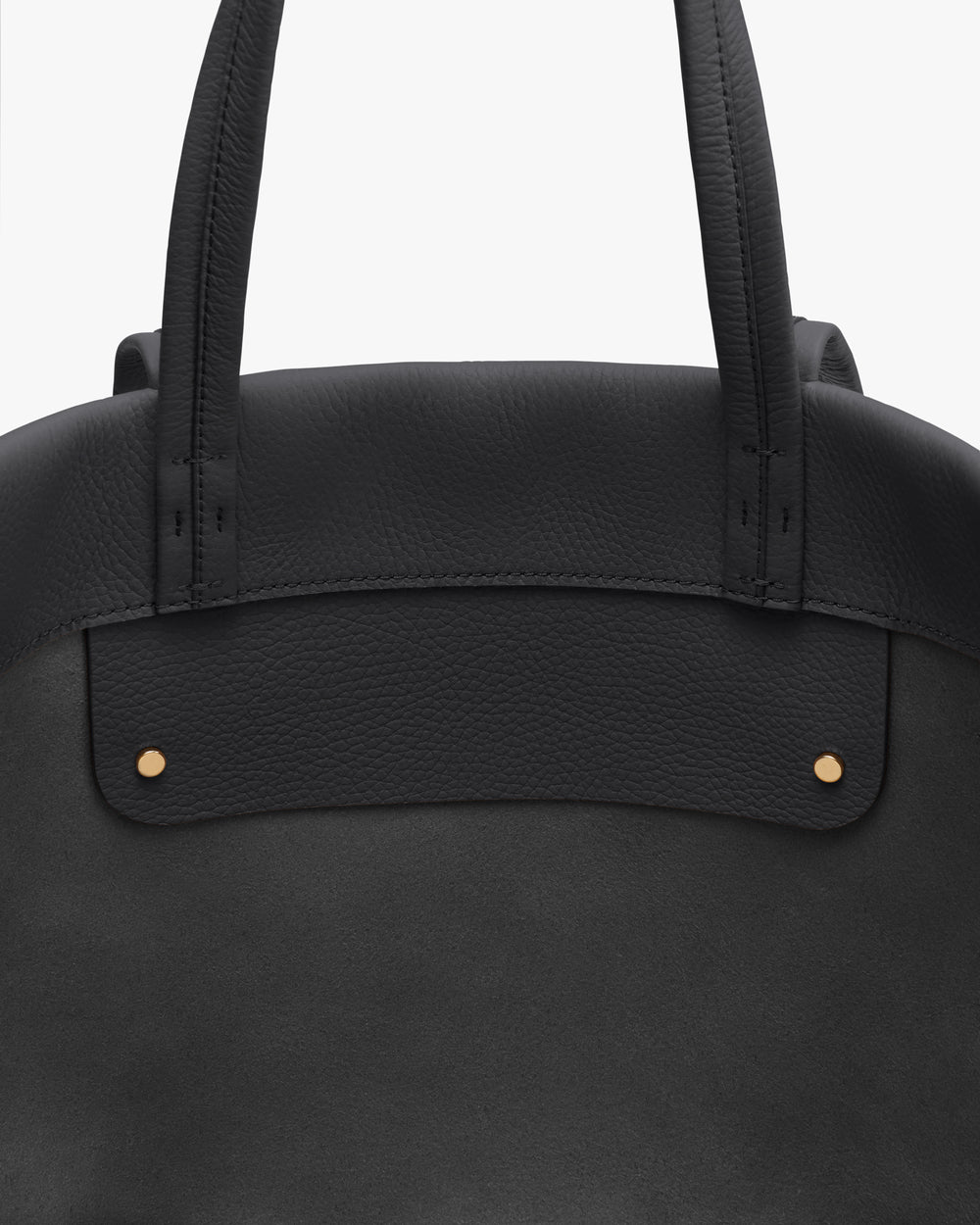 Close-up of a handbag with two handles and visible stitching.