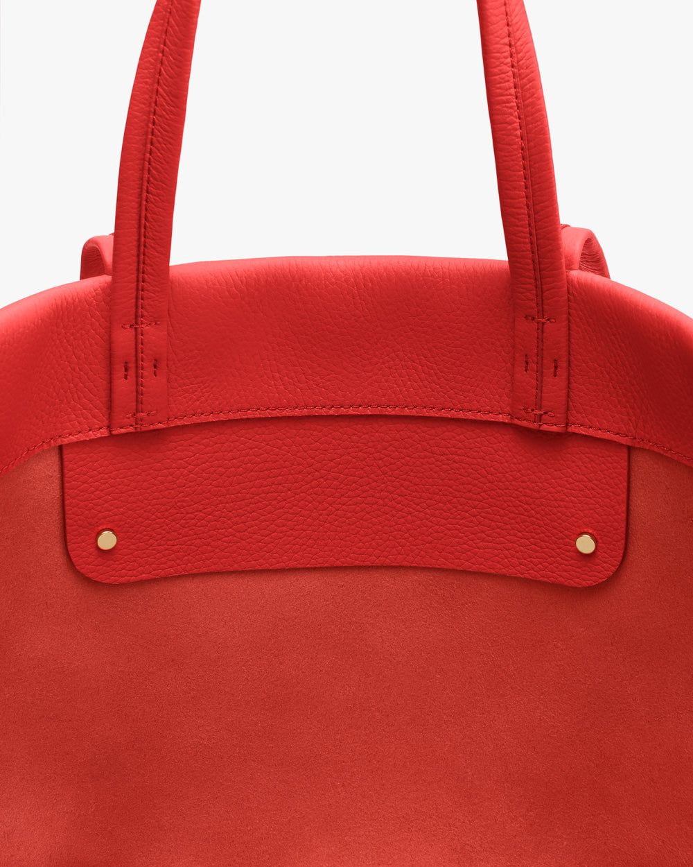 Tote bag close-up with two straps and small metal studs.