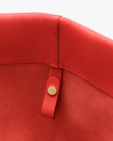 Close-up of a bag's interior with a button strap detail.
