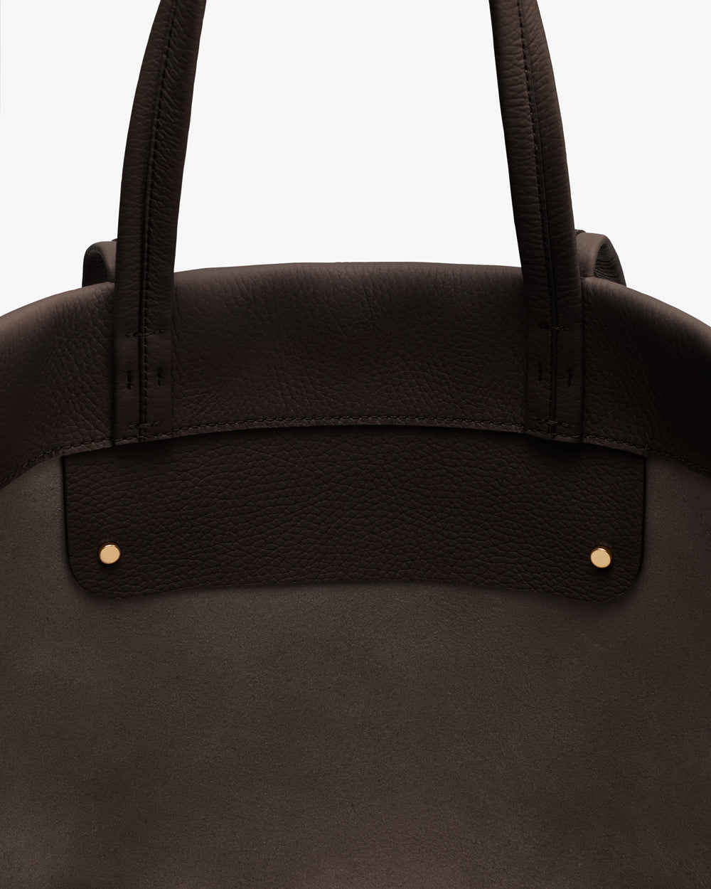 Close-up of a tote bag with two handles and metal studs.
