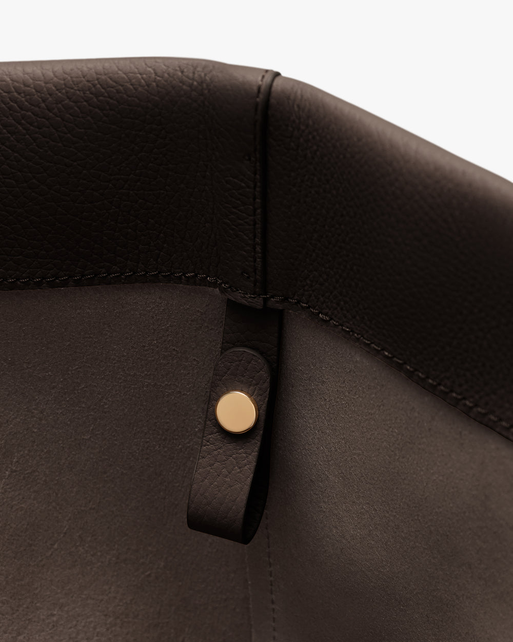 Close-up of a bag corner with a button detail.
