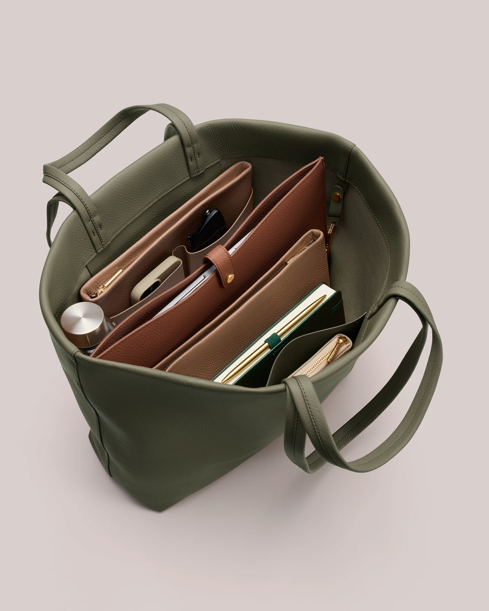 Open handbag with organized compartments and items inside.