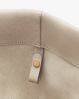 Close-up of a bag corner with button detail.