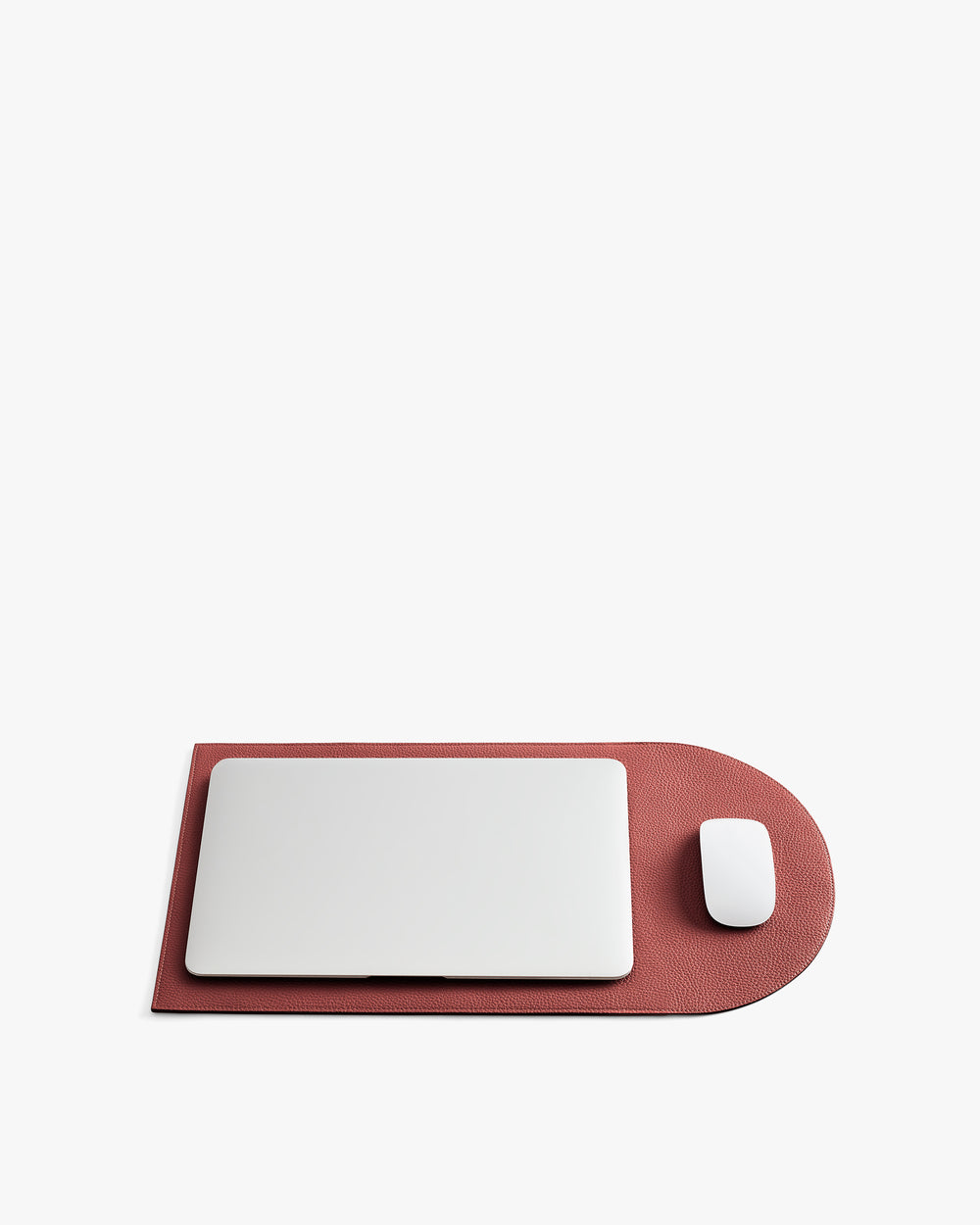 Laptop and mouse on a rounded rectangular mat.