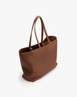 Large tote bag with long handles in an empty setting.