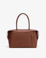 Handbag with two handles and a zipper closure on a plain background.