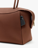 Travel bag with phone in side pocket, bag has zip and handles.