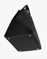 Tote bag with four metal feet and a structured design.