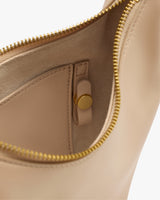 Open handbag with visible zipper and button inside.