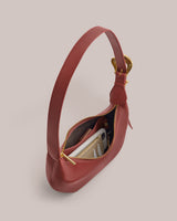 Handbag with open top displaying phone, wallet, and keys inside.
