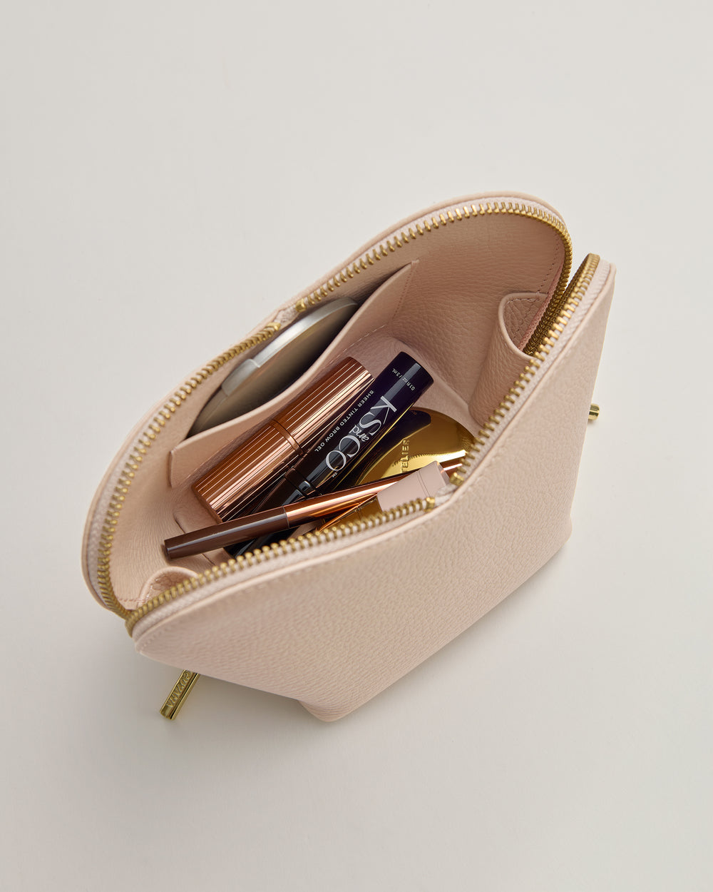 Open makeup bag with various cosmetics inside.
