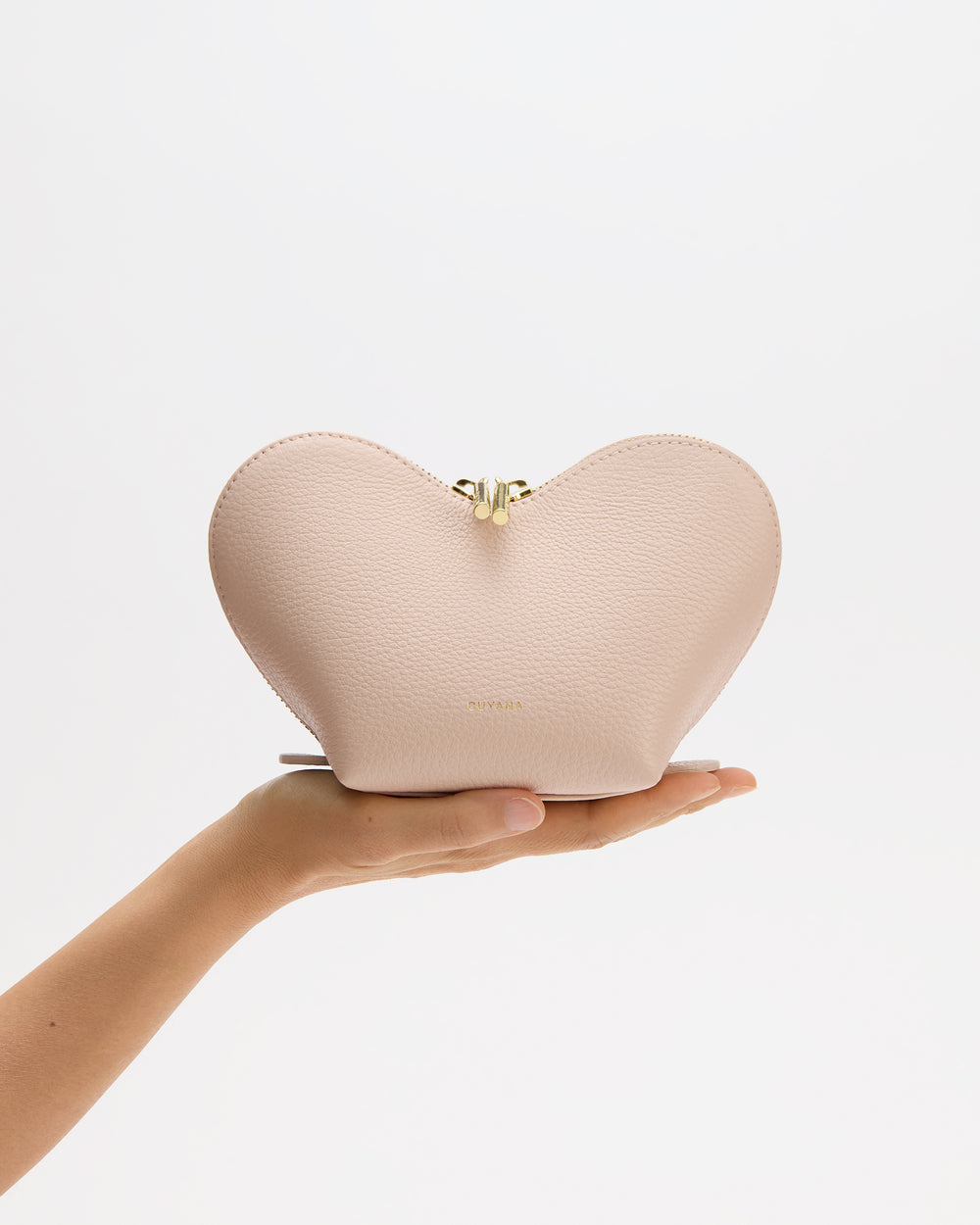 Heart-shaped bag held on a person's hand.